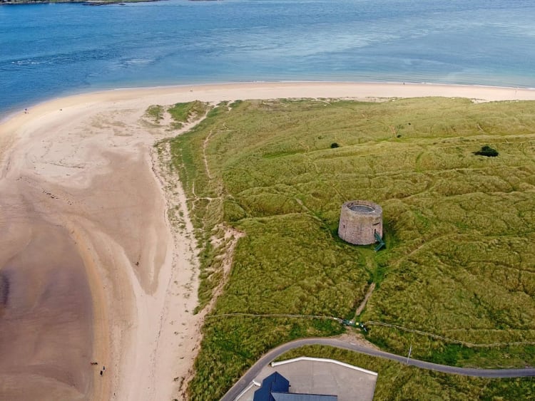 Greencastle, Irlanda &ndash; Vista a&eacute;rea de la costa arenosa con torre hist&oacute;rica