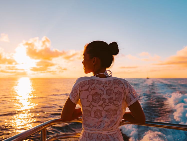Cruise ship vacation woman watching sunset boat deck on summer travel. Silhouette of tourist relaxing on outdoor balcony of boat ferry.