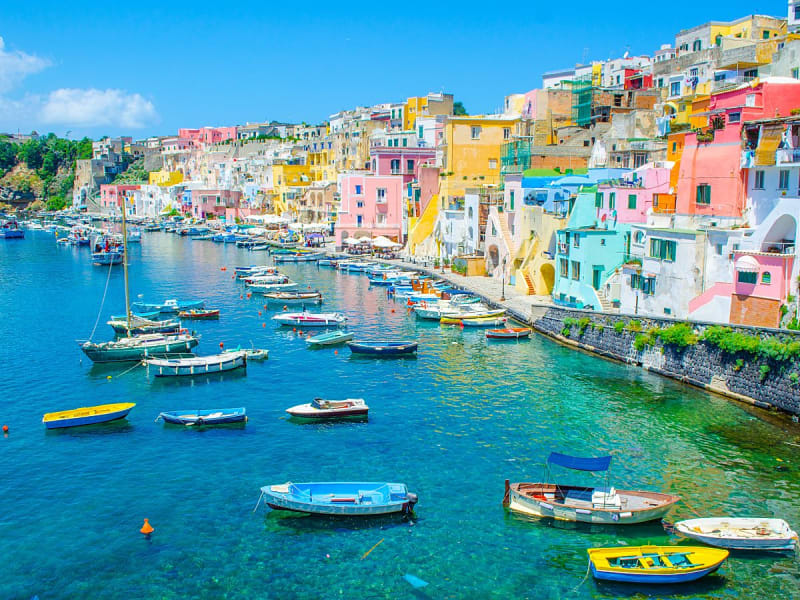Procida, Italien &ndash; Pastellfarbene Fassaden s&auml;umen die kleine Marina am Hang