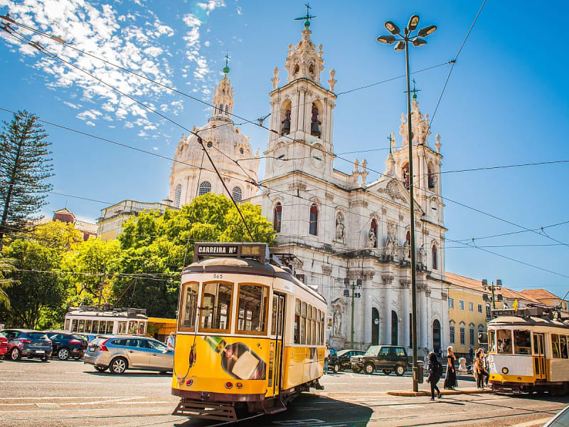 Lissabon, Portugal &ndash; Gelbe Stra&szlig;enbahn Linie 28 vor barocker Basilika