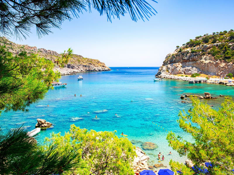 Rhodos, Griechenland &ndash; Klare Badebucht mit Felsen, Boot und gr&uuml;nem K&uuml;stenhang