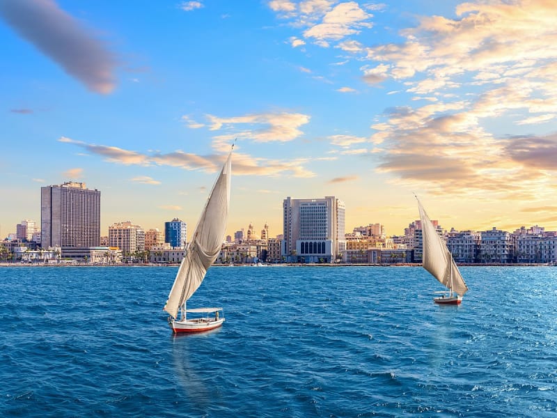 Alexandria, &Auml;gypten &ndash; zwei Segelboote vor moderner K&uuml;stenlinie im Abendlicht