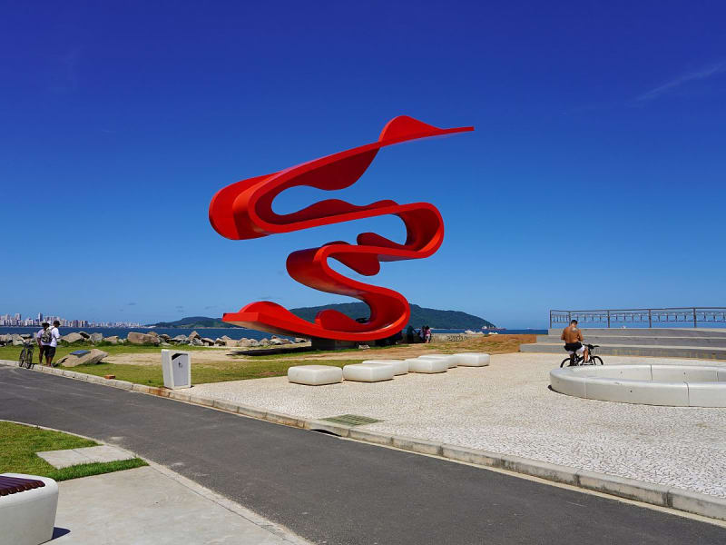 Santos, Brasilien &ndash; Rote K&uuml;stenskulptur &bdquo;Onda&ldquo; hebt sich vor tiefblauem Himmel ab