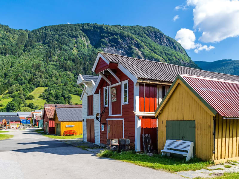 V&iacute;k &iacute; M&yacute;rdal, Island - Bunte Holzh&auml;user vor gr&uuml;nen Bergen am ruhigen Fjordufer