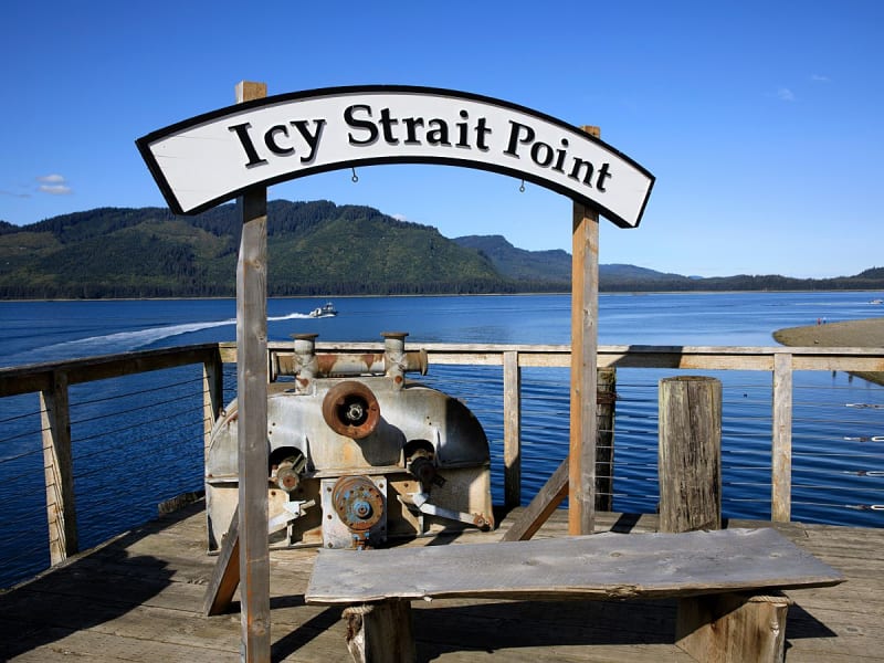Icy Strait Point, USA &ndash; Aussichtspunkt mit Schild vor blauem Wasser und Bergen
