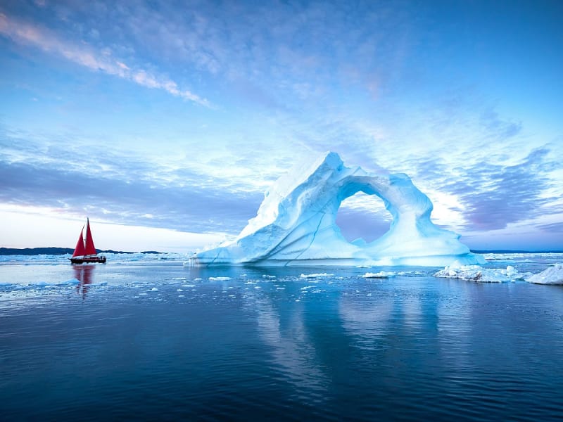 Diskobucht, Gr&ouml;nland - Eisberg mit Lochformation thront im blauen Abendlicht