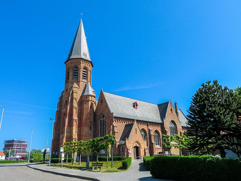 Zeebrugge, Belgien &ndash; Rote Backsteinkirche unter blauem Himmel