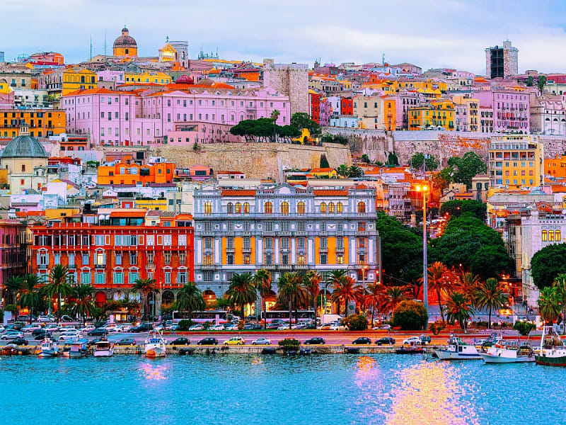 Cagliari, Italien &ndash; Blick auf die bunte Altstadt und den Hafen bei Abendlicht