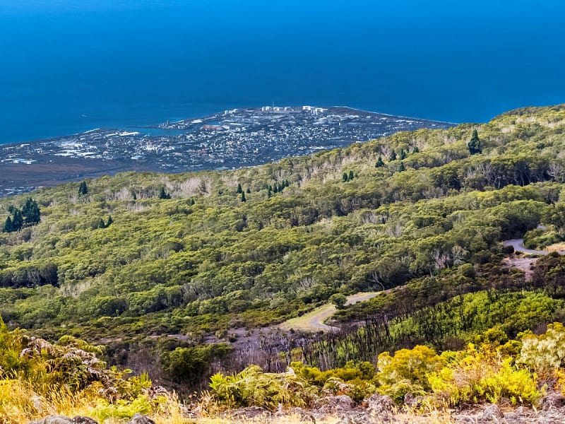 Le Port, R&eacute;union &ndash; Panoramablick von den Bergen auf die gr&uuml;ne Landschaft und die Stadt am Meer