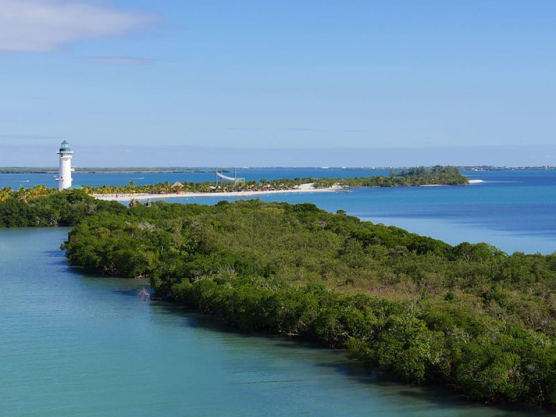 Harvest Caye, Belize &ndash; wei&szlig;er Leuchtturm ragt aus Palmenlandschaft und Mangroven
