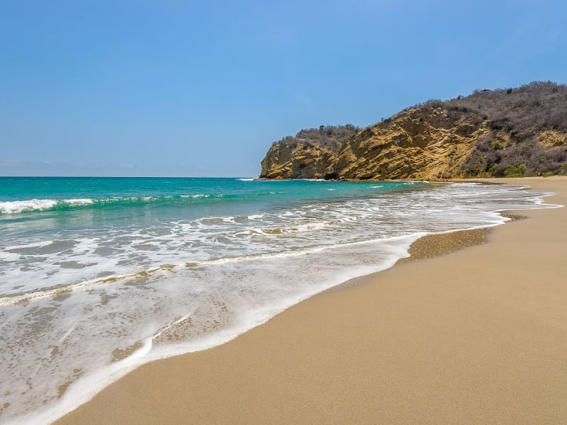 Manta, Ecuador &ndash; goldener Sandstrand mit t&uuml;rkisfarbenem Wasser und felsiger Landzunge
