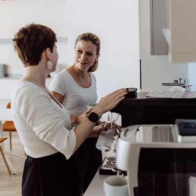 Zwei Mitarbeitende unterhalten sich in der Kaffee-Küche
