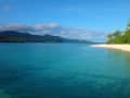 Mystery Island, Vanuatu - Sanfte Wellen treffen auf weißen Sand vor grünen Hügeln