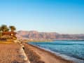 Aqaba, Jordanien – Sandstrand mit Palmen und Blick auf das Rote Meer