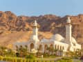 Aqaba, Jordanien – Weiße Moschee mit Minaretten vor Wüstenbergen