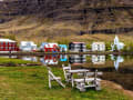 Seyðisfjörður, Island – Bunte Häuser spiegeln sich im ruhigen Wasser des Fjords