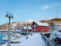 Narvik, Norwegen – Verschneiter Hafen mit roten Holzhäusern