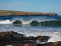 Scrabster, Écosse – Vagues devant une côte rocheuse avec phare