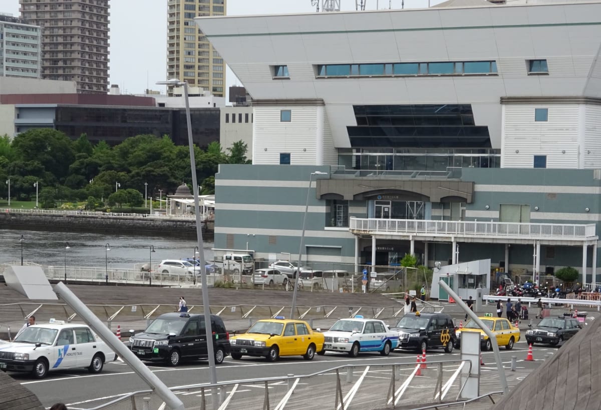 横浜市の無料のシャトルバスが廃止になったので
少ない本数のバスに乗るか最寄りの地下鉄の駅まで歩くか
もしくはタクシーの長い列に並ぶことになります。
この通りタクシーはたくさん来てくれているんだけど、二台づつしか乗車させない上に、トランクを開けて大きなスーツケースを入れたりしているから動くまでに時間がかかっています。 | 横浜