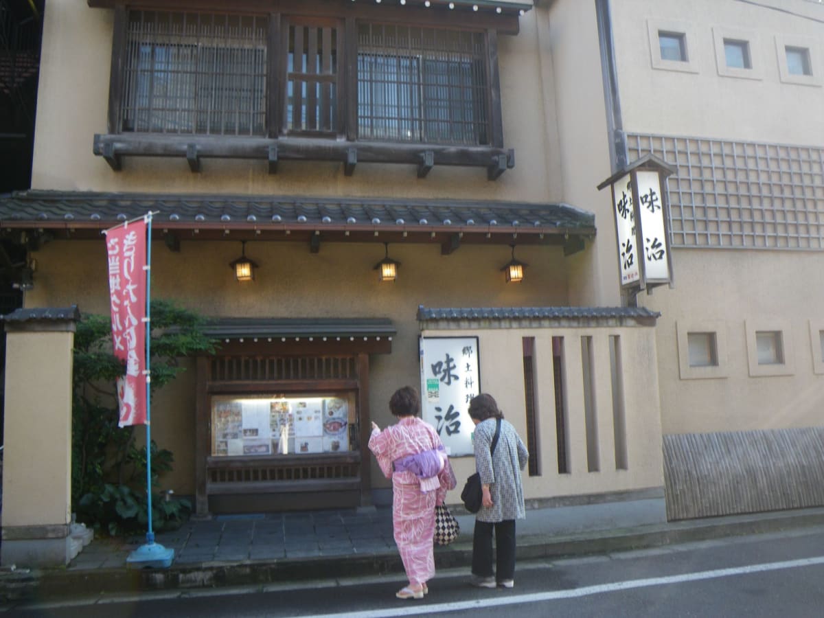 秋田では、竿灯まつりの前に食べるきりたんぽ鍋のお店も、お祭りの観覧席も、帰りのタクシーもすべて手配して準備万端。浴衣を着て午後3時の船のシャトルで街へと出かける。 暑い中お祭り気分に盛り上がる秋田市街をちょっとだけ歩いて、夕方5時に郷土料理のお店「味治」へ。地元のお酒を飲んで、お刺身やハタハタのお寿司、きりたんぽ鍋を取り分けてもらって食べてながら、板さんやおかみさんにお祭りの見どころを聞く。 そりゃ町内の人たちが担ぐ演技は迫力があるよ、企業のグループとは年季が違うからね、とか、最近は提灯の紙の品質が良くなって、そう簡単には燃えないから倒れてきても大丈夫、などと教えてくれる。 各町内会では子供の頃から竿を担ぐ練習をして、選抜もあって、実力ある特別な人たちだけがお祭りに出演できるそうだ。 | 秋田