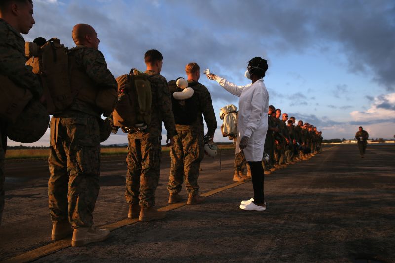 A health worker takes the temperature of U.S. Marines arriving to take part in Operation United Assistance on October 9, 2014 near Monrovia, Liberia.