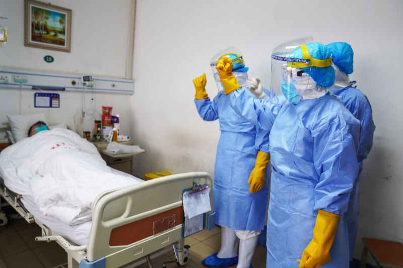 This photo taken on January 28, 2020 shows medical staff members cheering up a patient infected by the novel coronavirus in an isolation ward at a hospital in Zouping in China's easter Shandong province.