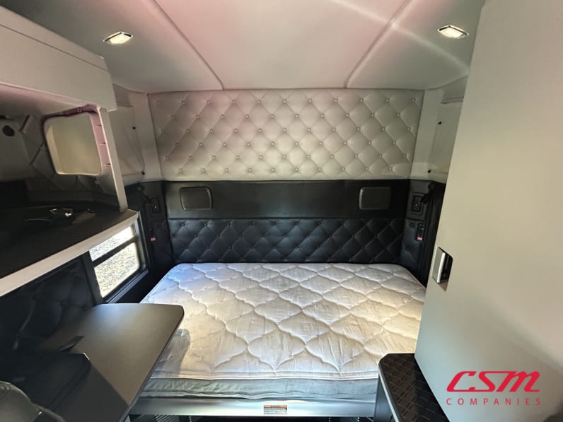 Interior wide sleeper view for this 2023 Kenworth W990 (Stock number: UPJ240230)