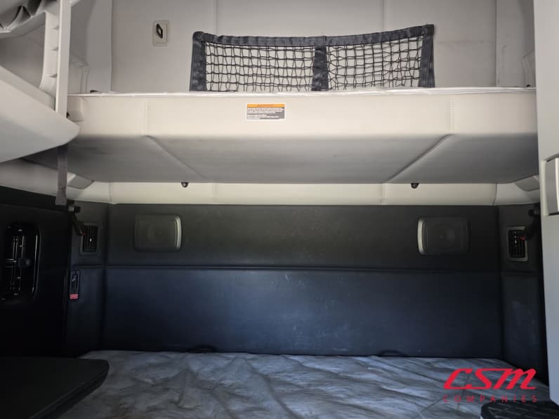 Interior wide sleeper view for this 2023 Kenworth T680 (Stock number: UPJ216776)