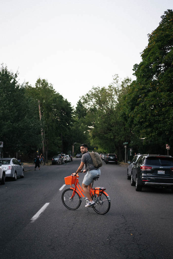 Payam crossing the street on a bike