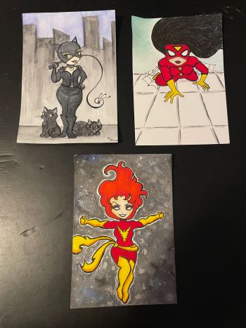 Image of Dark Pheonix, Catwoman, and Spider-Woman pieces by Marlene, 4x7 – mixed media on paper