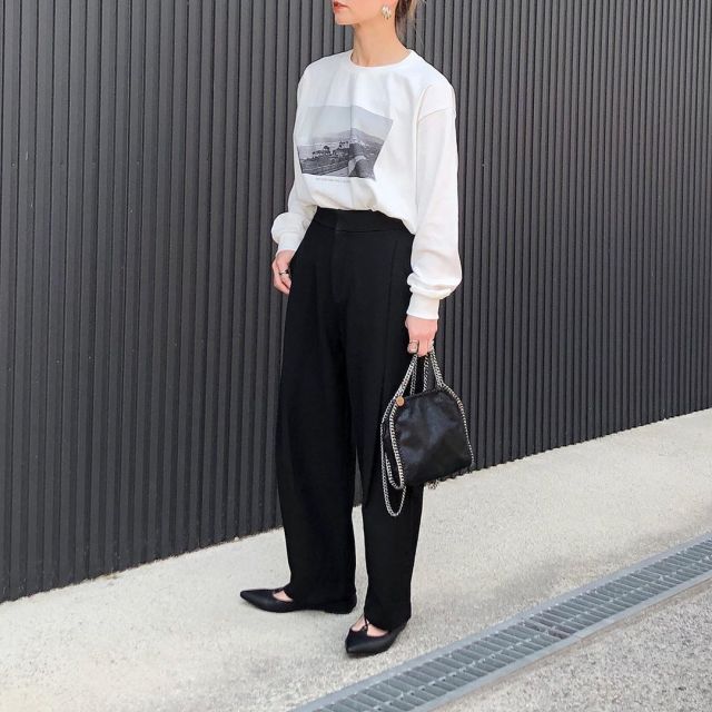 足まわりにゆとりがあるパンツに白のプリントTシャツをインして