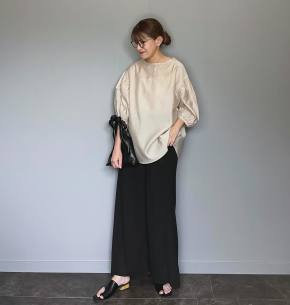 ツヤ素材のベージュトップス×黒ボトム