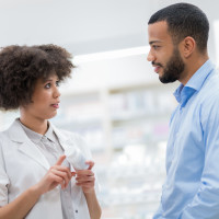 Pharmacist talking to man