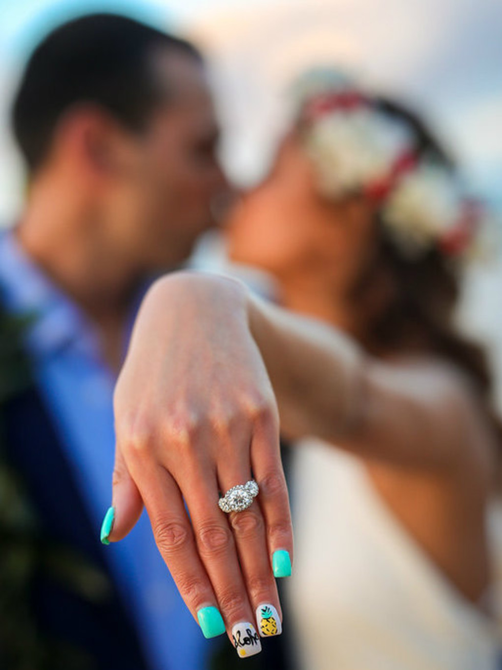 Bride and groom showing off wedding ring