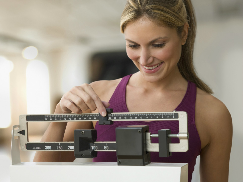 Woman weighing herself on scale