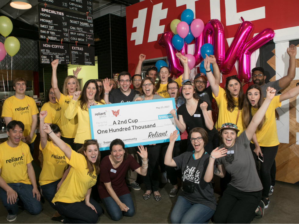 A 2nd Cup employees receive a $100,000 check from Reliant Gives