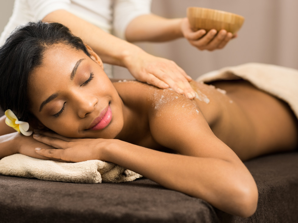 Woman receiving a passion fruit agave body scrub