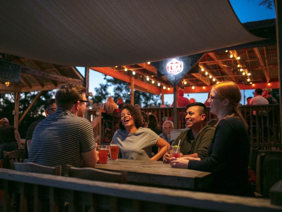 Friends laughing on a bar's patio