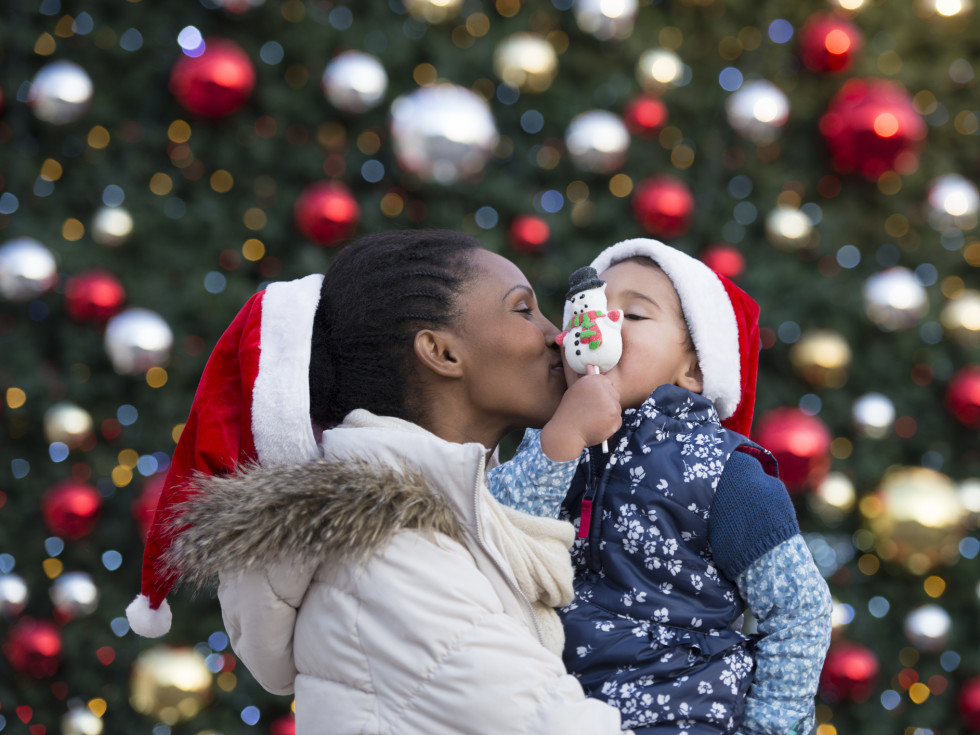 Mom kissing kid at Christmas