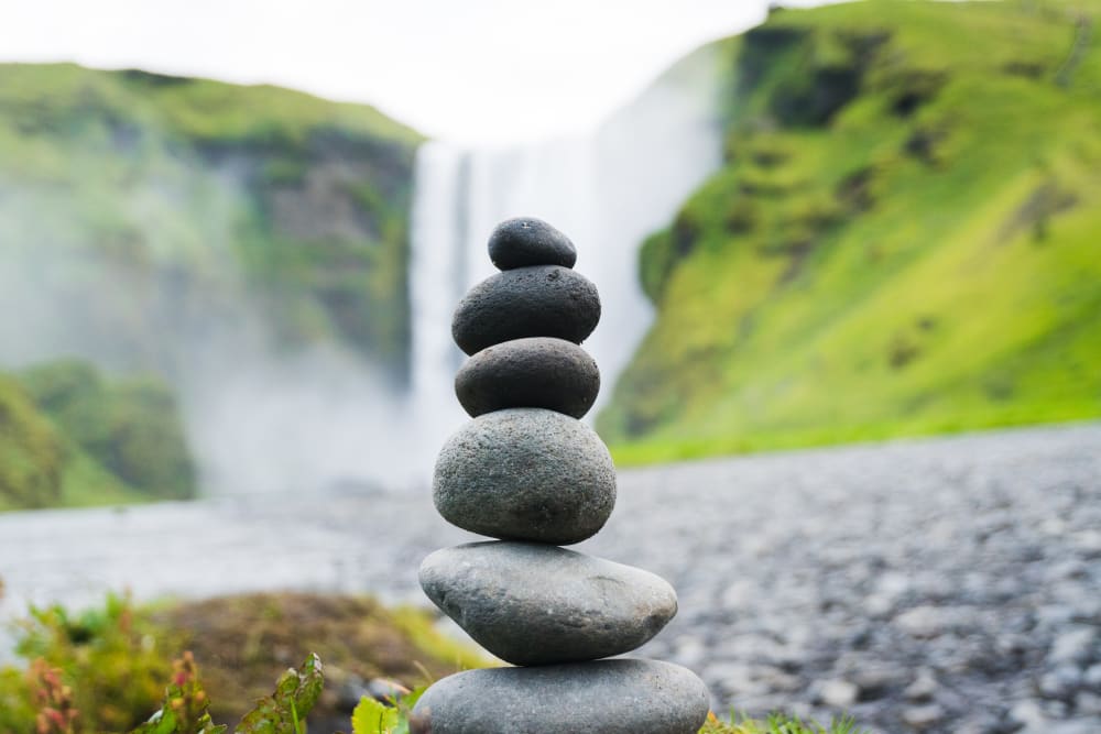 Balancing stones with a backdrop of a waterfall