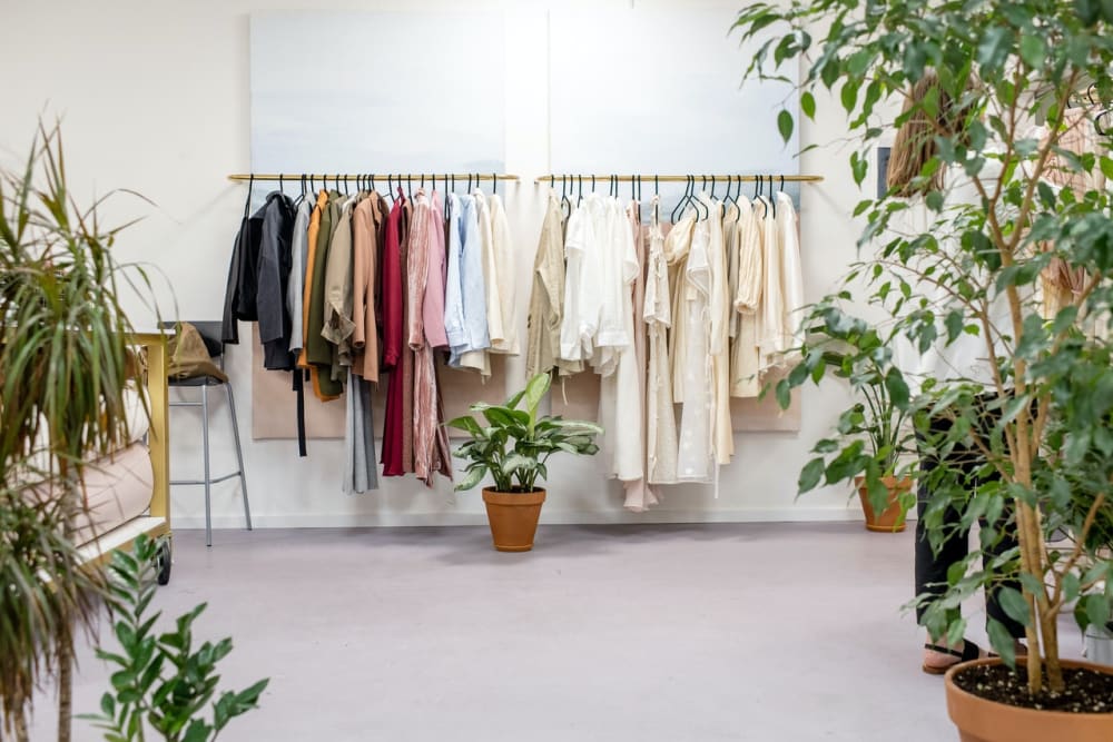 A selection of colourful womens clothing hanging on an open clothes rack