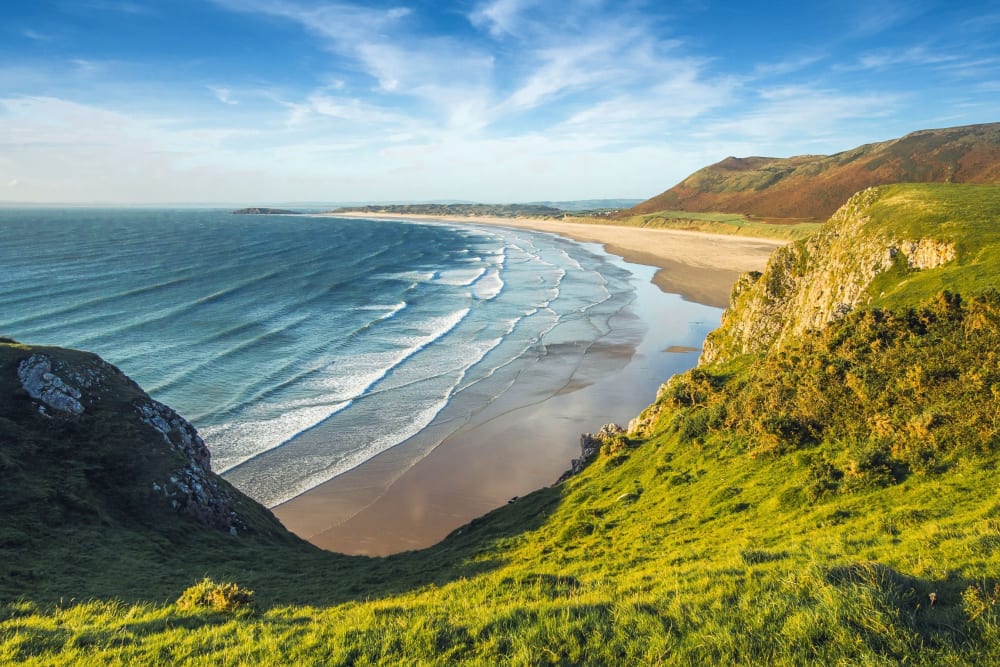 Shoreline of a secluded beach surrounded by mountainous cliffside