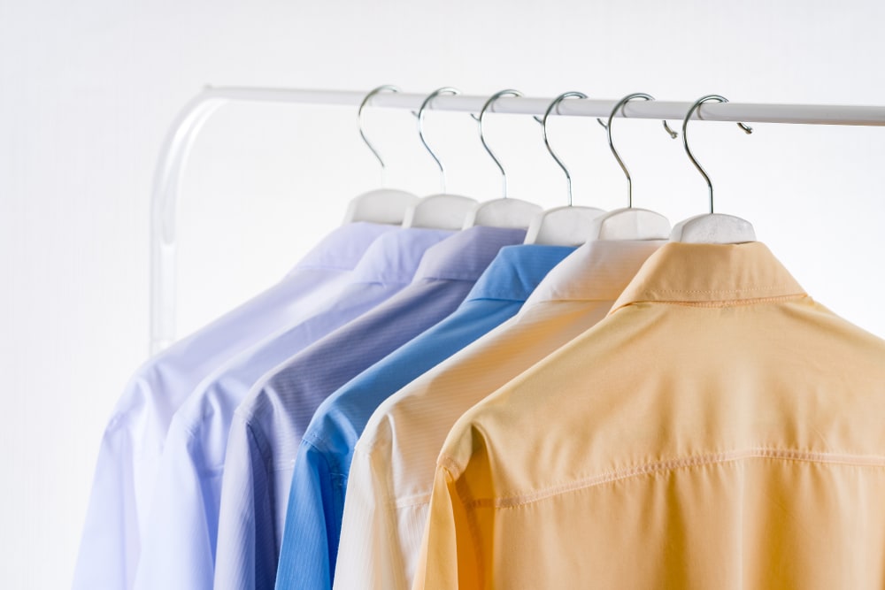 A hangar showing six hanging shirts of the same style but different colours