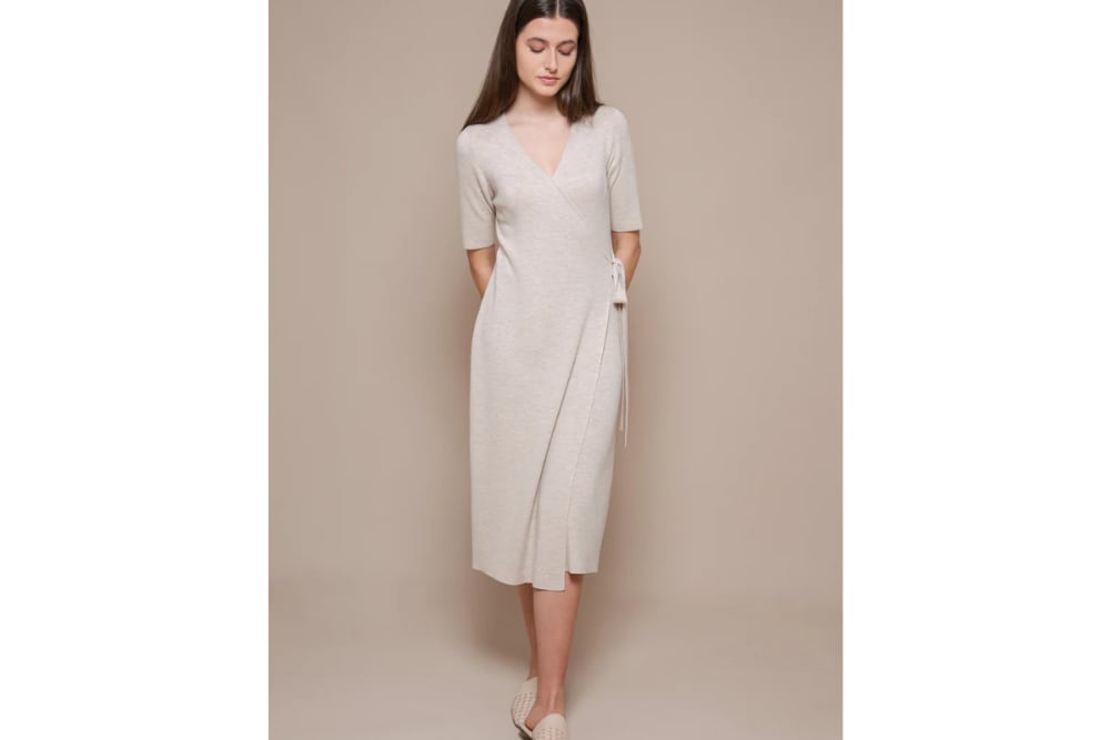 Woman wearing the Francis Stories beige midi wrap Vera dress