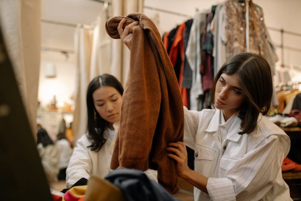 Two women sifting through items in a thrift store