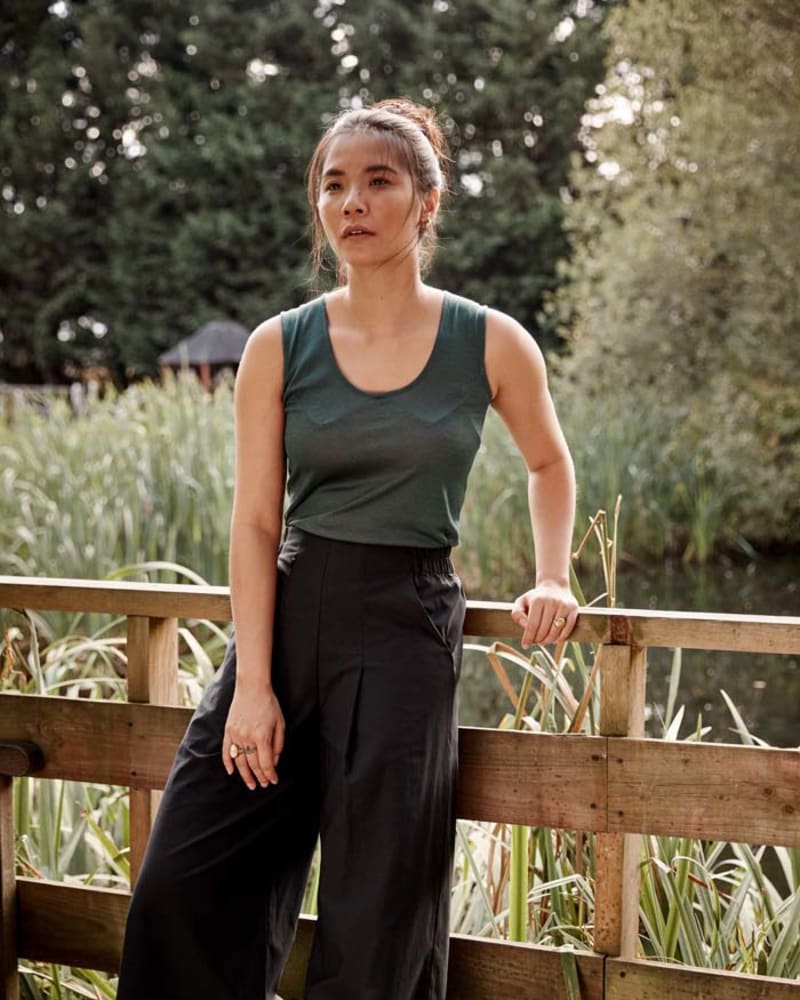 Woman in green tank top wearing wide legged trousers