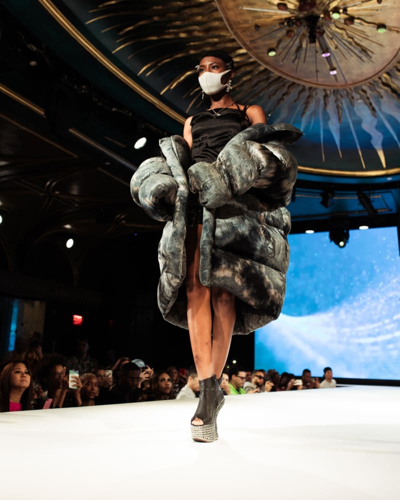 Woman in Gray Jacket Standing on Fashion Runway