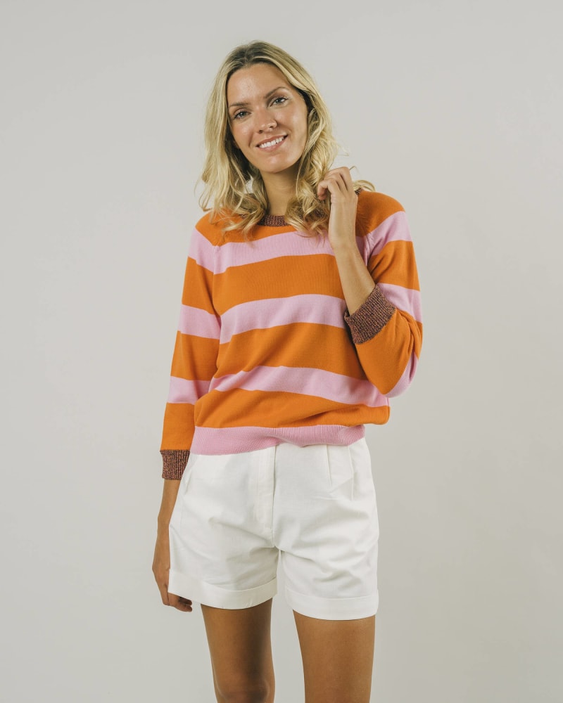 Woman wearing a pink and orange striped long sweater