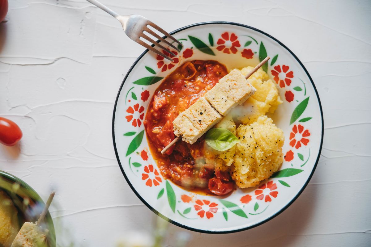 Kremna polenta in paradižnikova omaka servirana skupaj z vegi ražnjiči.