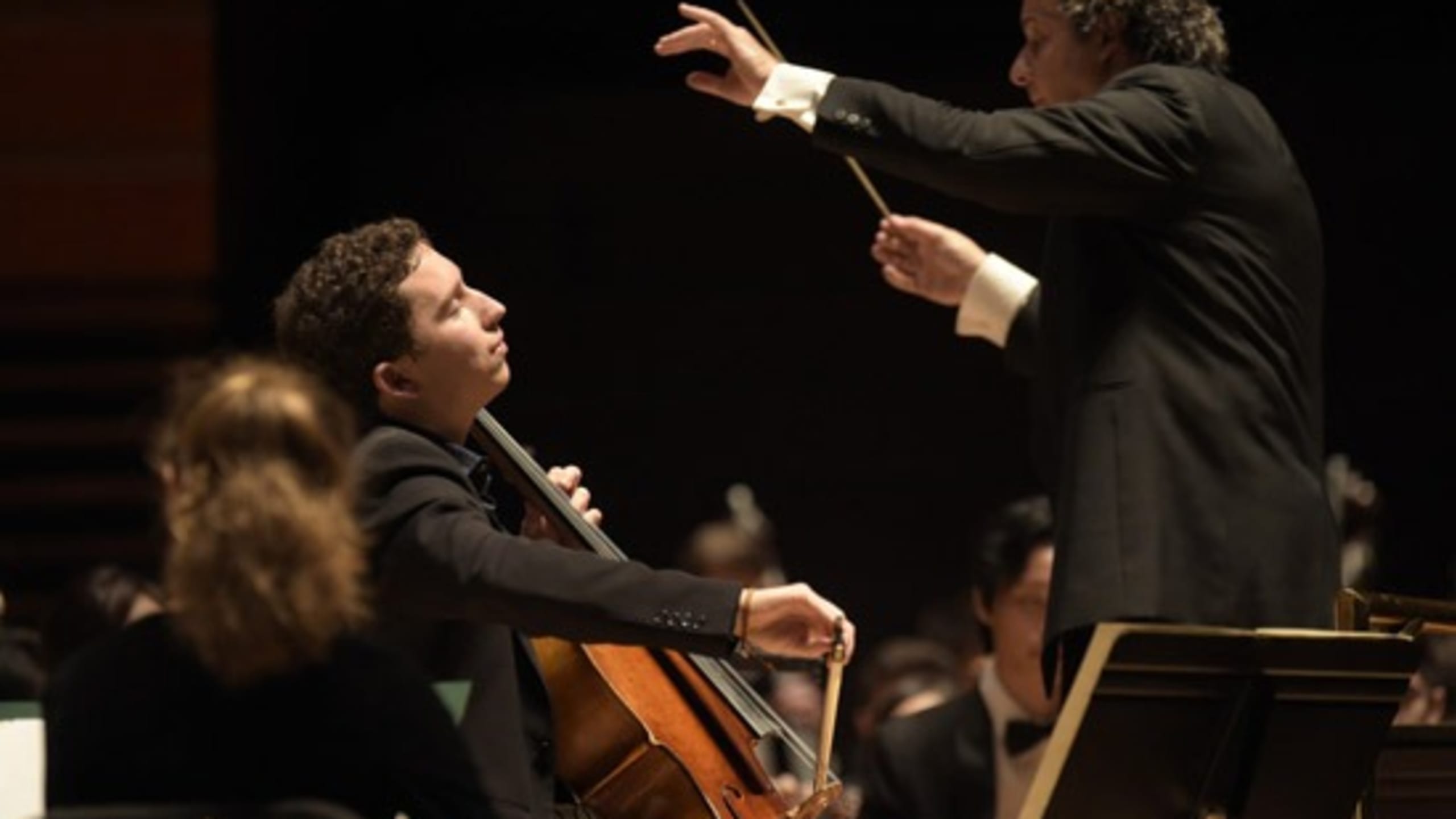 Cello soloist performing with orchestra.